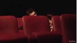 gif of woman blowing a man in their seats in a movie theater